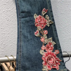 Niebieskie jeansy damskie flare z elastycznego denimu, z haftem