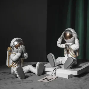 Figurka siedzącego astronauty, dekoracja z dłońmi przy hełmie - ujęcie produktu