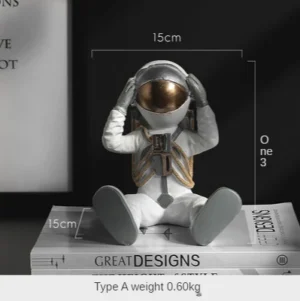 Figurka siedzącego astronauty, dekoracja z dłońmi przy hełmie - ujęcie produktu