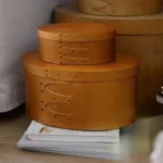 Pudełko owalne z drewnianą pokrywką i widocznymi nitami - ujęcie produktu