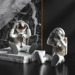 Figurka siedzącego astronauty, dekoracja z dłońmi przy hełmie - ujęcie produktu
