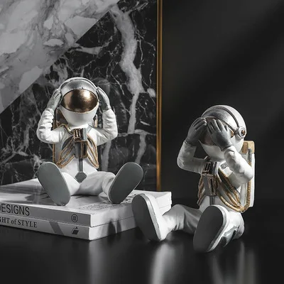 Figurka siedzącego astronauty, dekoracja z dłońmi przy hełmie - ujęcie produktu