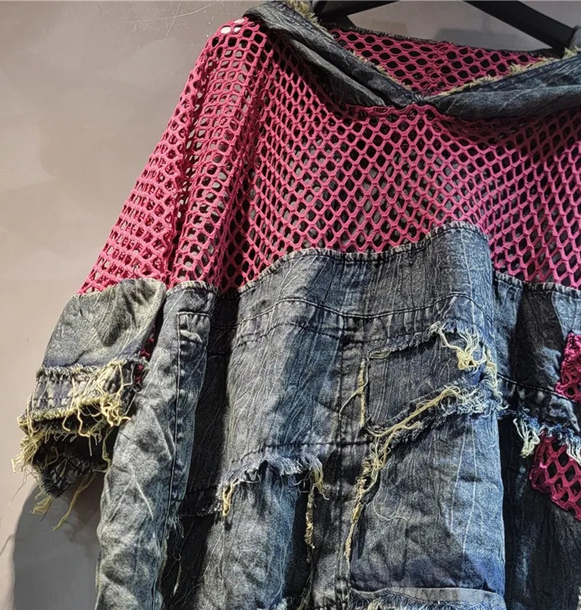 zbliżenie wersji różowej: duże oczka siatki, kaptur i strzępione panele denimu
