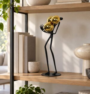 Figurka metalowa ludzik ze złotymi kulami 41 cm, czarna, na biurko - regał z książkami i ceramiką w minimalistycznym salonie, figurka na półce