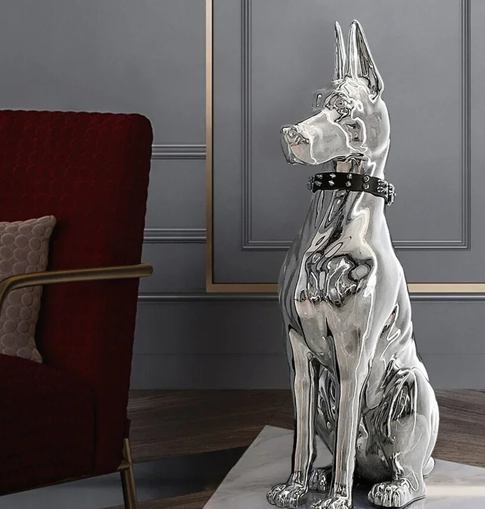 doberman przy bordowym fotelu, wyraźne odbicia wnętrza na lustrzanej powierzchni
