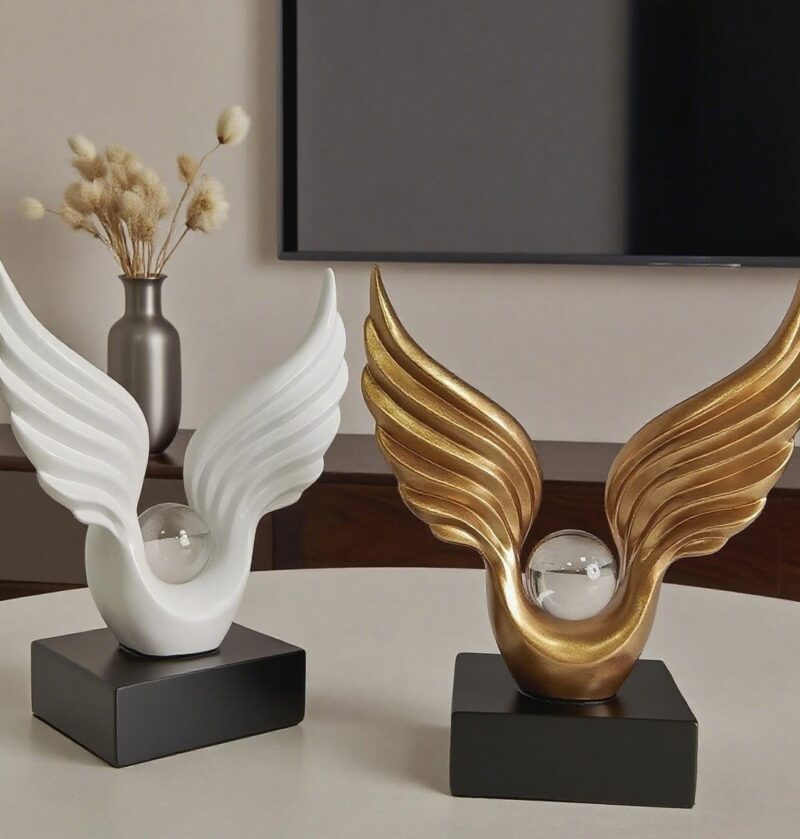 Figurka skrzydła anioła z kulą na czarnej podstawie, żywica, 22 cm - szafka RTV w stylu glamour z figurką i wazonem z suszkami