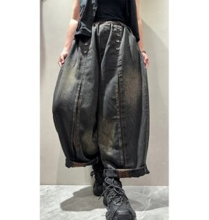 Jeansy damskie szerokie z ozdobnymi guzikami, na gumce, sprane vintage - modelka w jesiennym parku miejskim, gruby sweter, buty trekkingowe