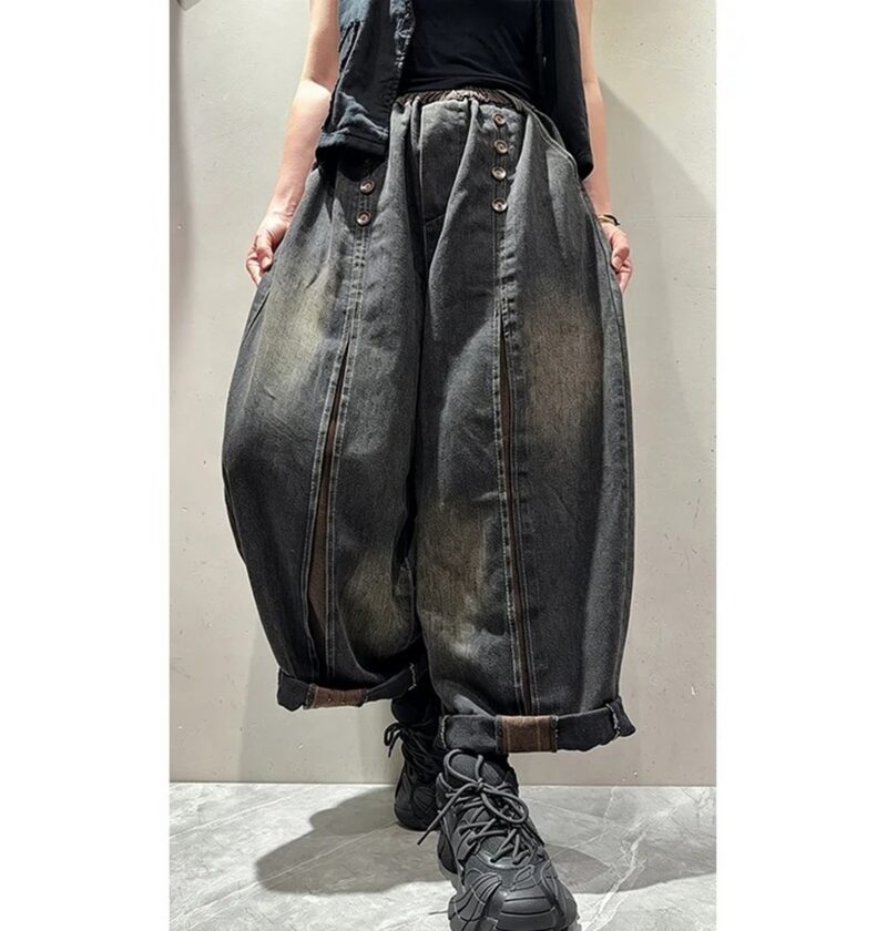 Jeansy damskie szerokie z ozdobnymi guzikami, na gumce, sprane vintage - modelka w jesiennym parku miejskim, gruby sweter, buty trekkingowe