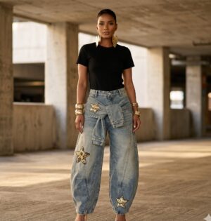 Jeansy damskie szerokie z naszywkami gwiazd i wiązanym pasem - betonowy parking miejski w ciepłym świetle, modelka w niebieskich jeansach z gwiazdami, bez logo