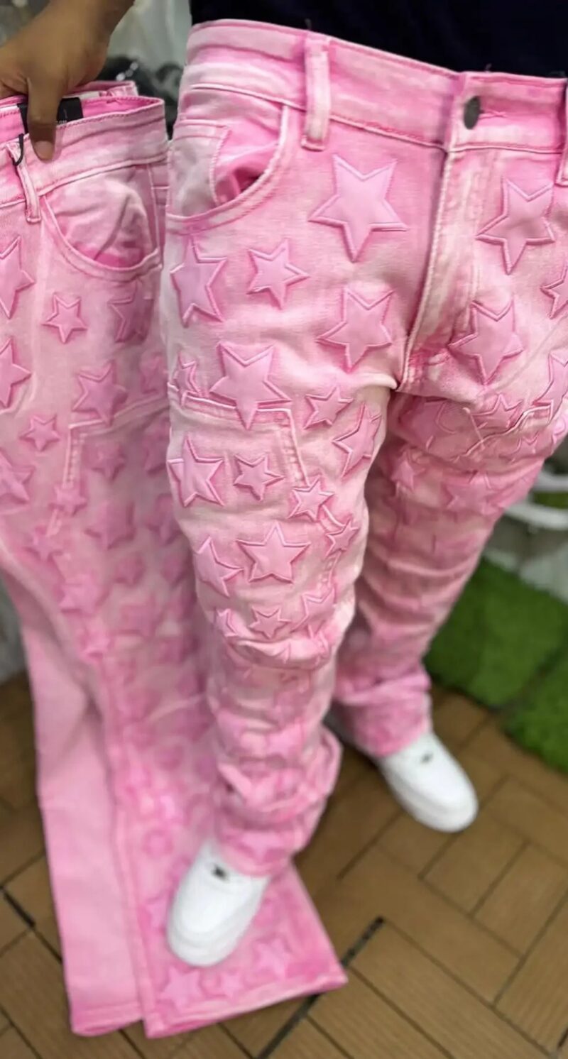 Jeansy damskie szerokie do kostek, 9 wzorów i zdobień do wyboru - oryginalne ujęcie różowych jeansów w gwiazdy na modelce stojącej na chodniku