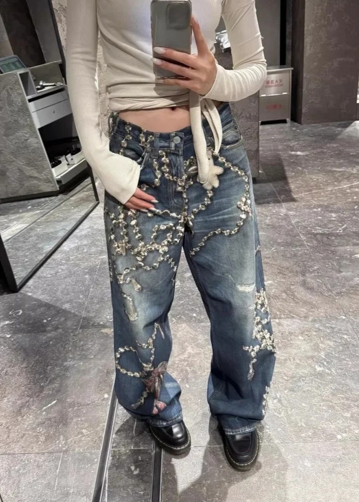 stylizacja jeansów z białą bluzką i czarnymi butami
