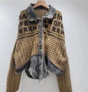 Kardigan damski patchworkowy z jeansem, splot warkoczowy, oversize - kawiarnia z ceglaną ścianą, modelka w kardiganie khaki z czarnym golfem i plisowaną spódnicą midi