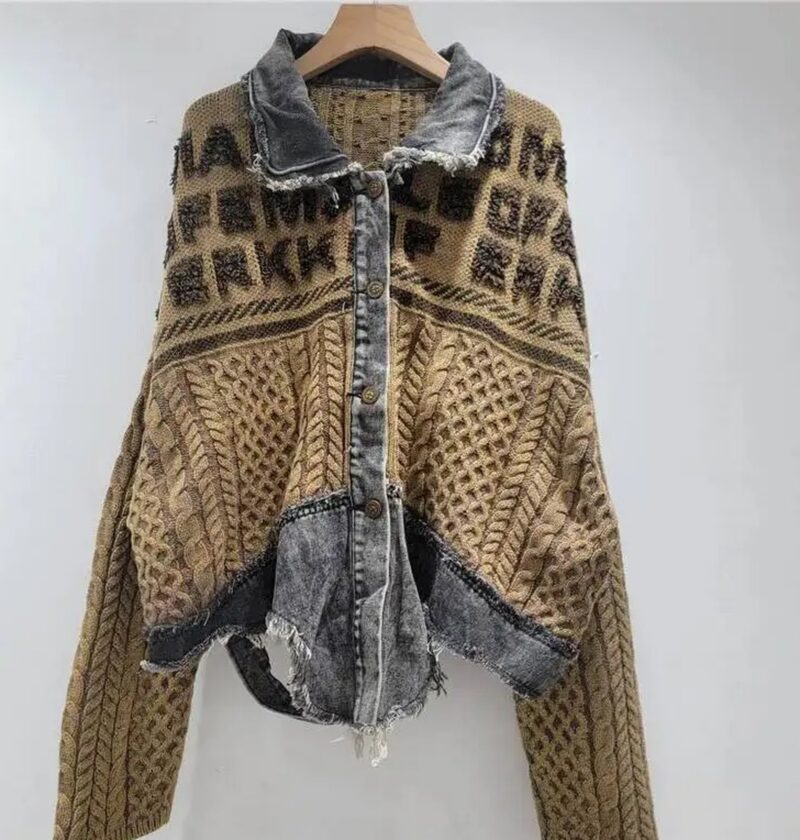Kardigan damski patchworkowy z jeansem, splot warkoczowy, oversize - kawiarnia z ceglaną ścianą, modelka w kardiganie khaki z czarnym golfem i plisowaną spódnicą midi