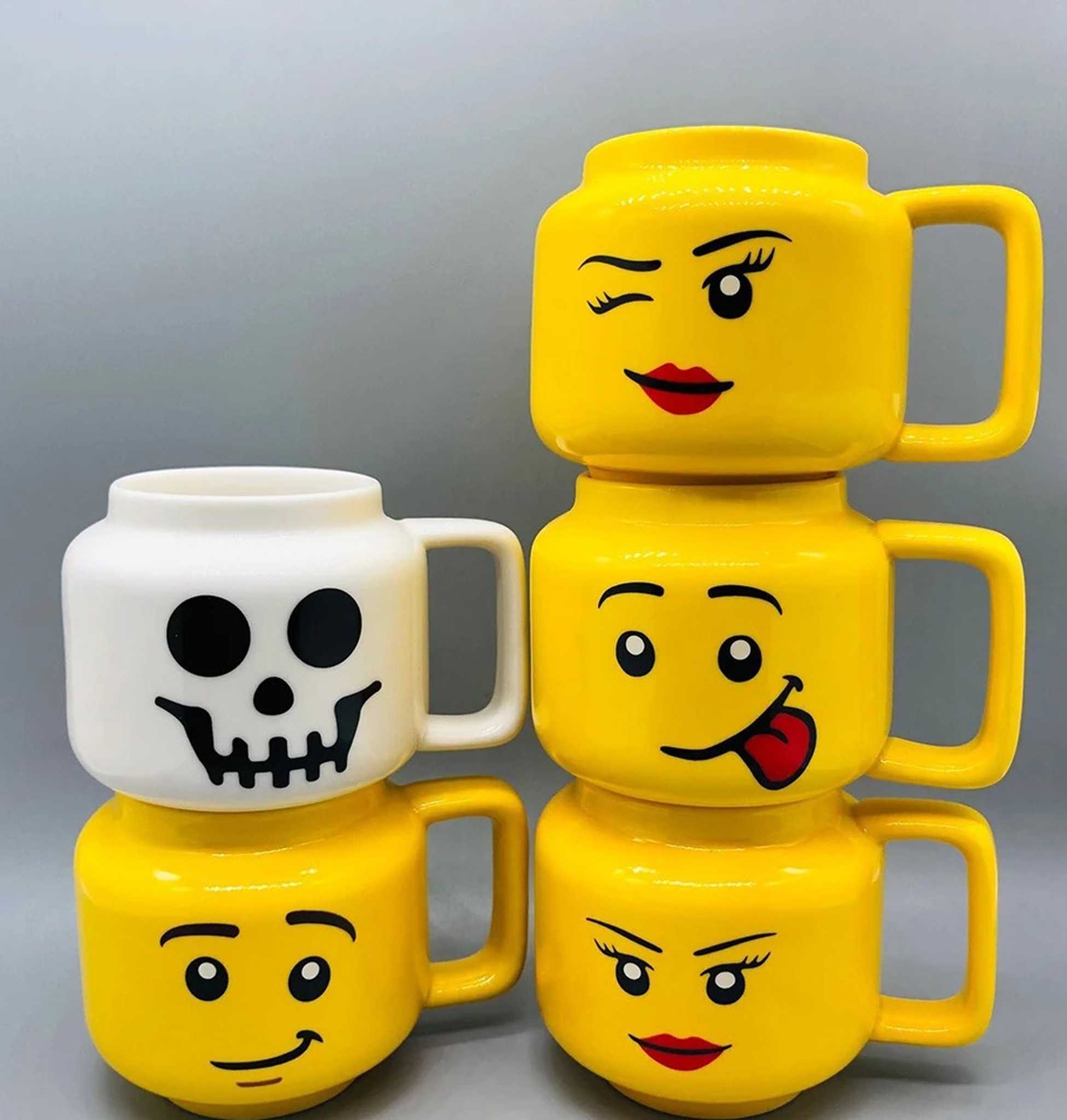 kubki z różnymi minami jako zestaw prezentowy na stole