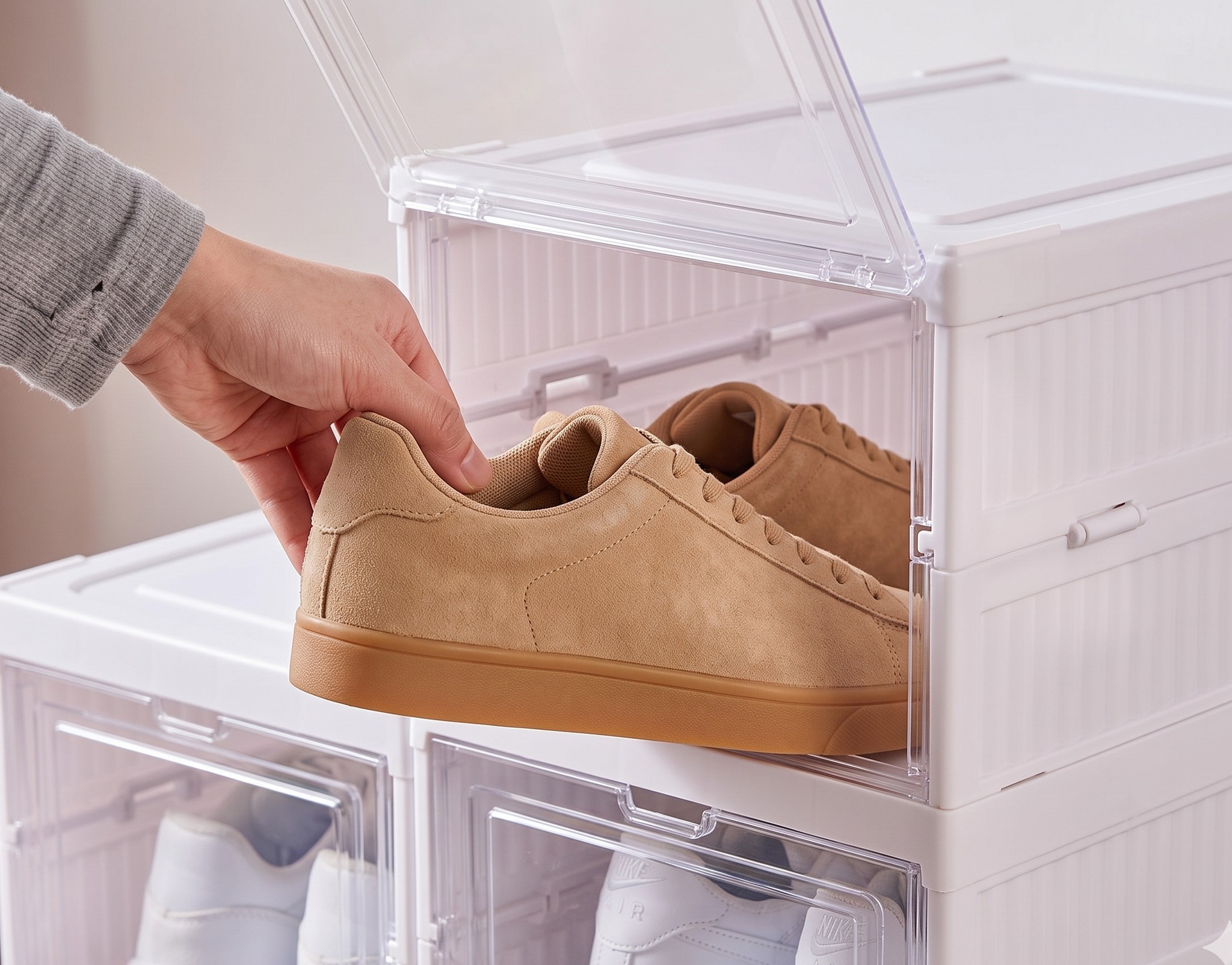 dłoń wyjmuje sneaker bez logo z otwartej przegrody