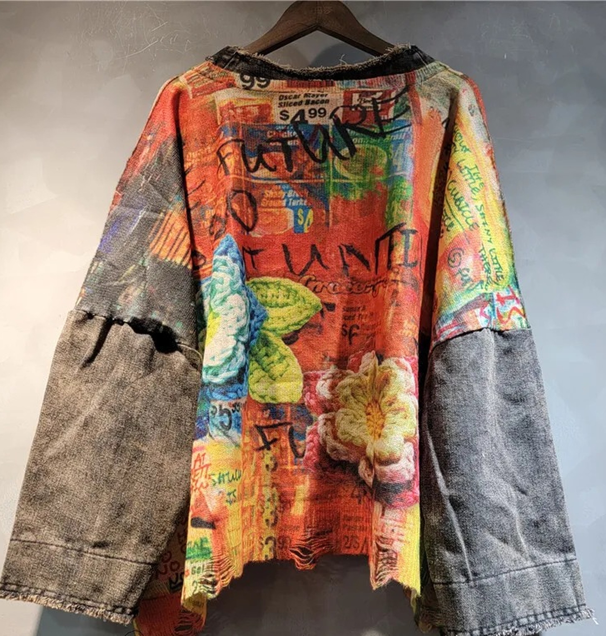 sweter z boku na wieszaku: szeroki rękaw z denimu z przetarciem i postrzępiony, asymetryczny dół
