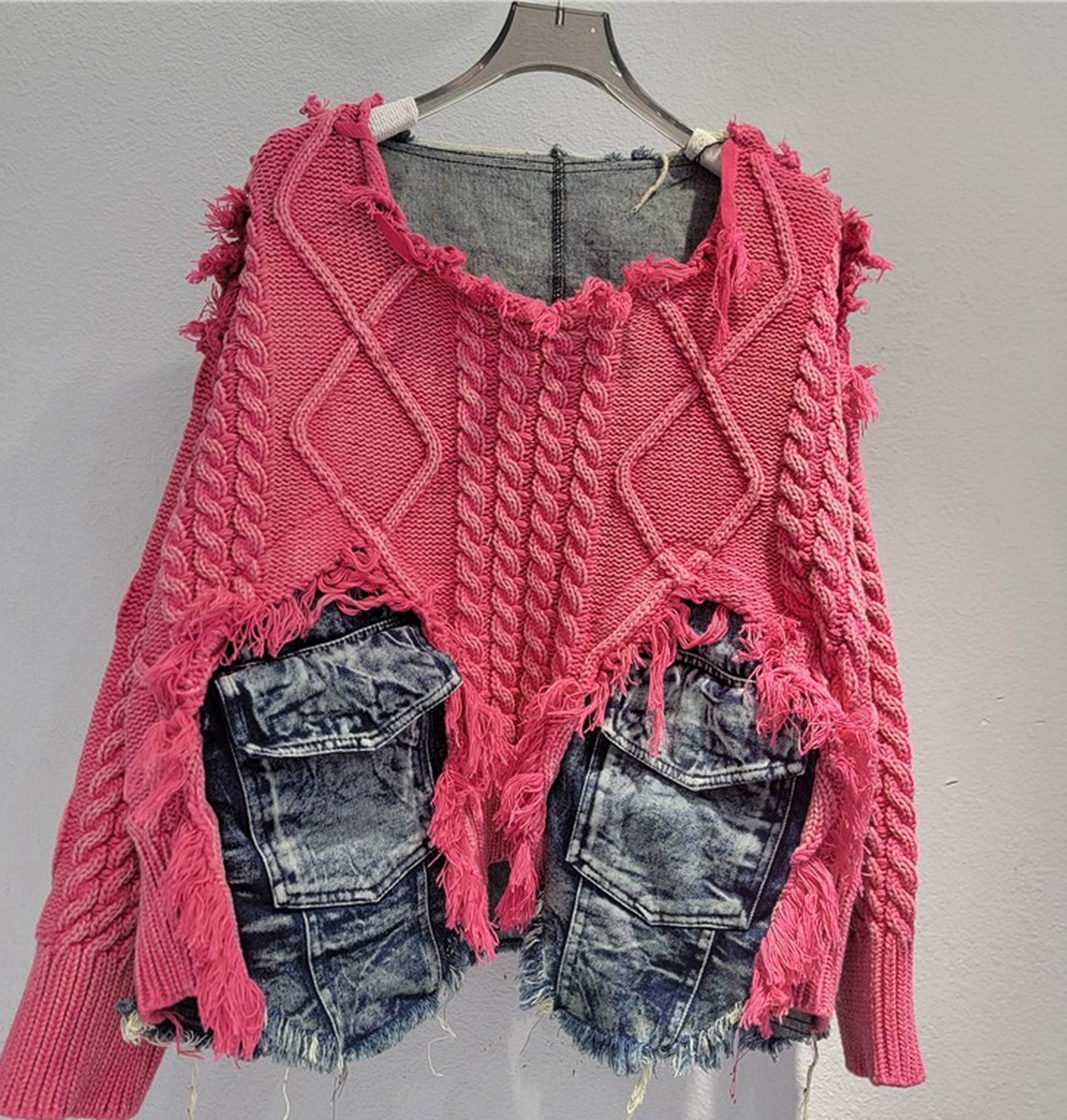 różowy sweter z dwiema niebieskimi jeansowymi kieszeniami i frędzlami wokół
