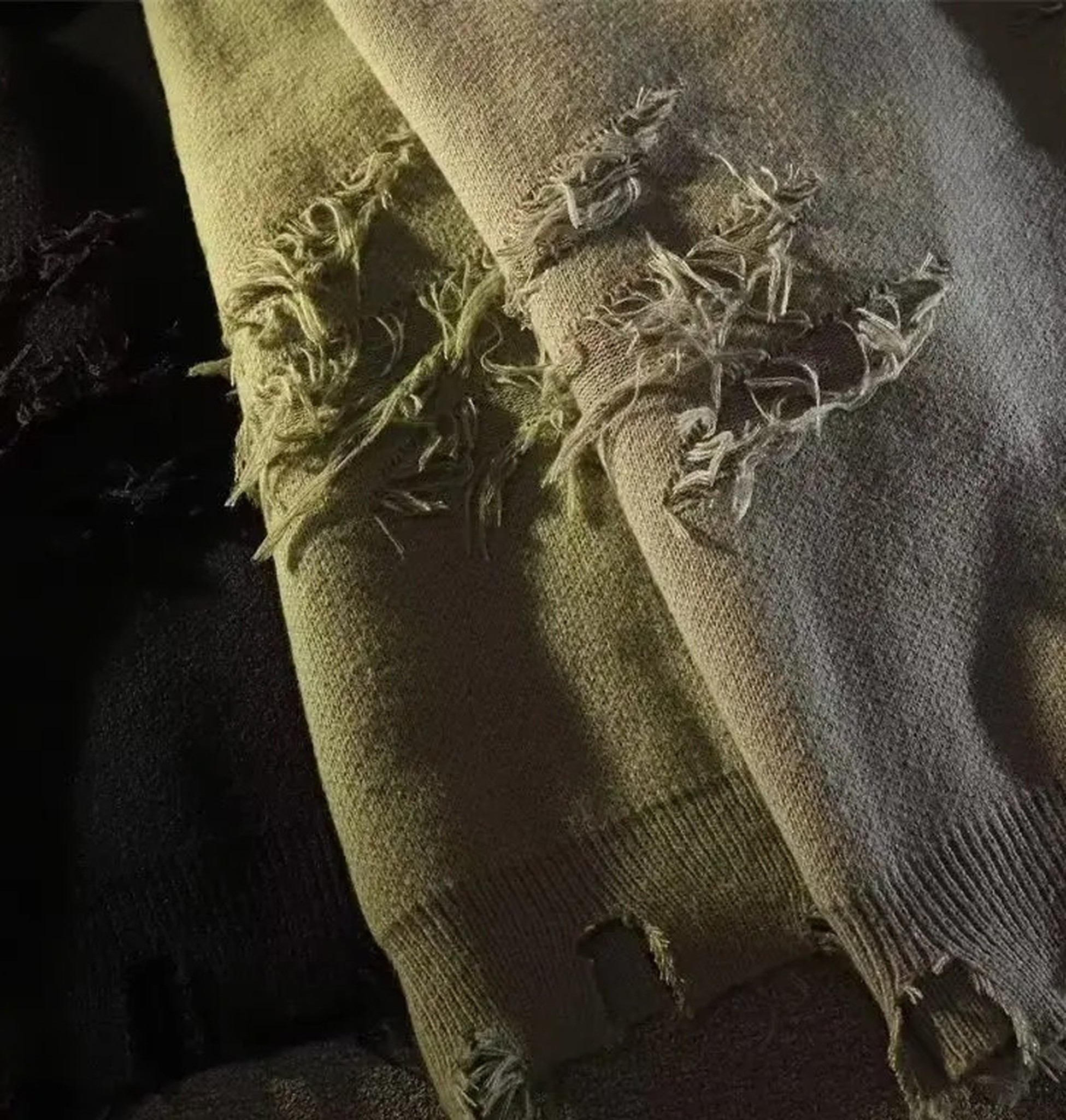 zbliżenie rękawa z dziurami i frędzlami