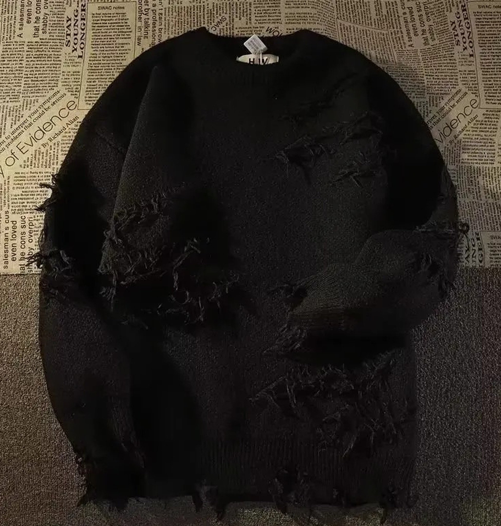 czarny sweter w pełnym widoku obok zielonego, flat lay
