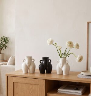Wazon ceramiczny w kształcie ciała 14 cm, z uszkami, nowoczesny - jasna minimalistyczna komoda w salonie, trzy wazony z białymi kwiatami