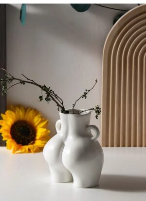 Wazon ceramiczny w kształcie ciała 14 cm, z uszkami, nowoczesny - stół w stylu japandi przy łukowym panelu z drewna, gałązki w wazonie